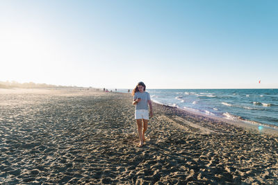 Man standing on beach against clear sky