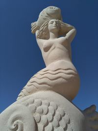 Low angle view of statue against blue sky