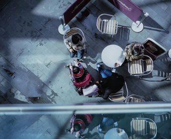 Directly above shot of people sitting at sidewalk cafe on sunny day