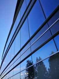 Low angle view of glass building against sky