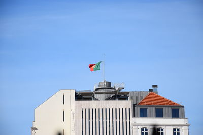 Low angle view of flag on building against sky