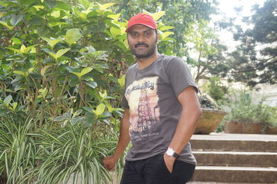 Portrait of young man standing against plants