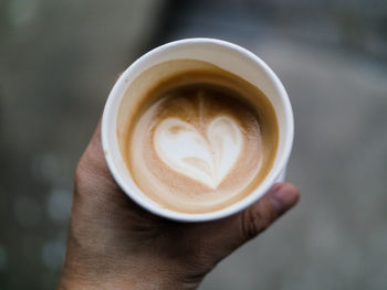 Close-up of hand holding coffee cup