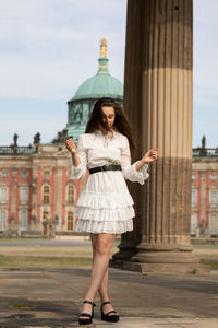 Full length of woman standing against building