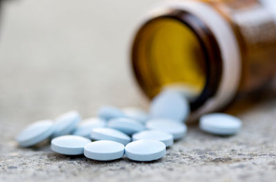 Close-up of medicines spilling from bottle