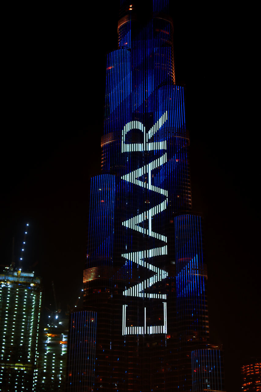 LOW ANGLE VIEW OF ILLUMINATED BUILDING AT NIGHT