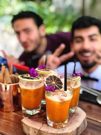 Drink on table with men gesturing at restaurant