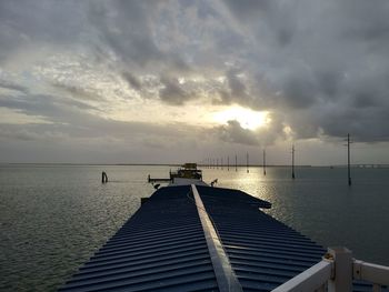 Pier over sea against sky during sunset