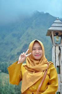 Portrait of smiling woman against mountain