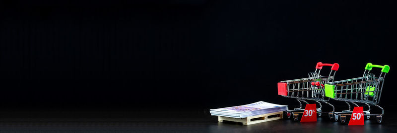 Stack of multi colored pencils on table against black background