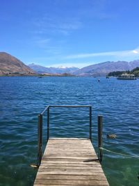 Pier over lake against blue sky