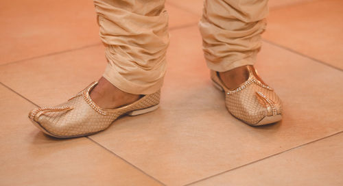 Low section of man standing on tiled floor