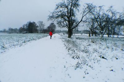 Man walking on snow covered landscape