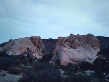 Rocks on landscape against sky