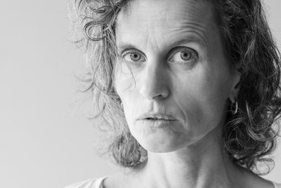 Close-up portrait of woman against white background