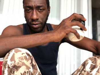 Portrait of man holding mug while sitting at home