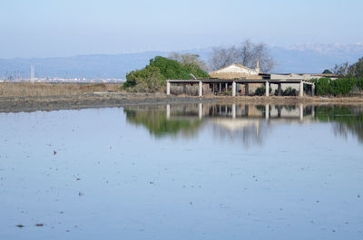 Scenic view of lake by building against sky