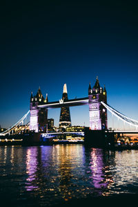 View of suspension bridge in city at night