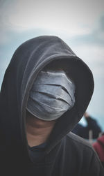 Close-up of man covering face with surgical mask