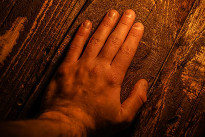 Cropped hand of man touching wooden table