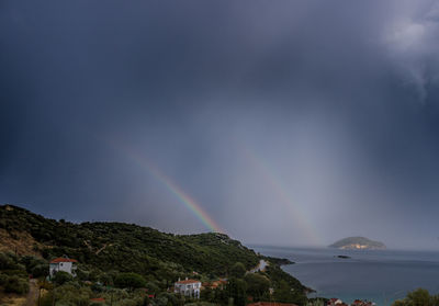 Scenic view of rainbow over mountains against sky