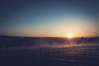 Scenic view of agricultural field against sky during sunset