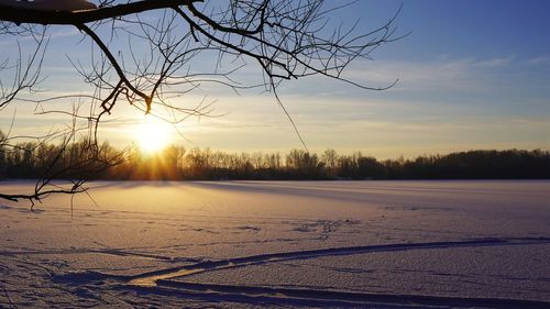 Scenic view of snow field against sky during sunset