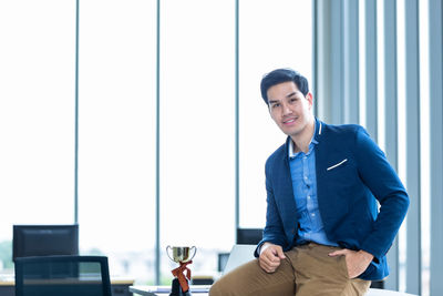 Portrait of young man standing in office