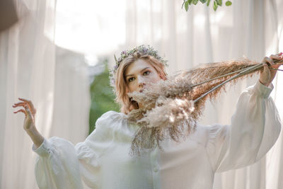 Portrait of woman holding white flowers