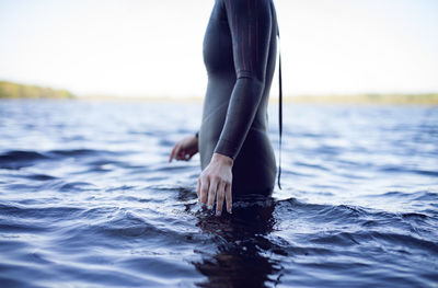 Side view midsection of female swimmer standing in lake