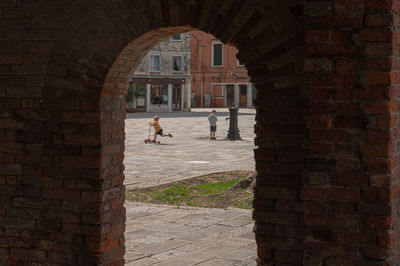 People walking on brick wall of building