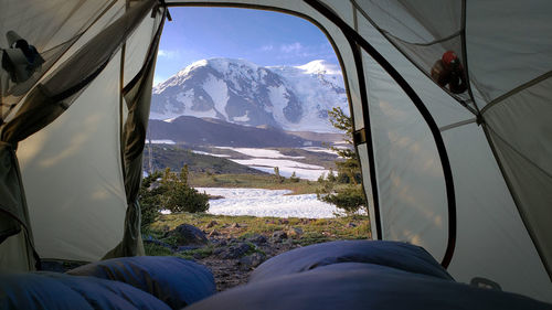Low section of people on snowcapped mountains against sky