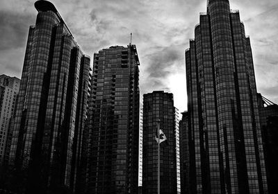 Low angle view of modern building against cloudy sky