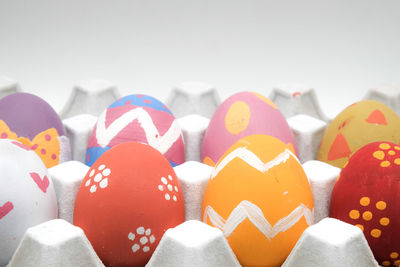 Easter eggs in carton against white background