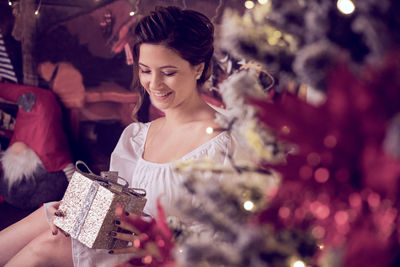 Portrait of woman holding christmas tree