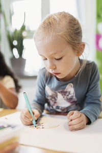 Girl using felt tip pen in drawing class