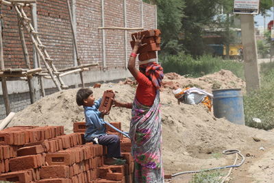 Boy holding umbrella at construction site