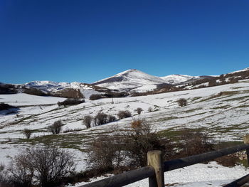 Scenic view of snowcapped mountains against clear blue sky