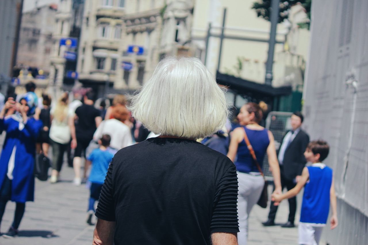 rear view, focus on foreground, women, city, real people, incidental people, street, adult, people, lifestyles, group of people, hair, architecture, men, blond hair, walking, hairstyle, day, crowd, city life, white hair