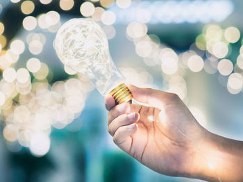 Close-up of hand holding illuminated lighting equipment