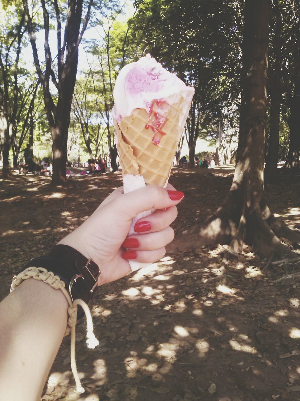 person, holding, lifestyles, part of, leisure activity, pink color, cropped, tree, freshness, flower, sunlight, food and drink, day, human finger, unrecognizable person, sweet food