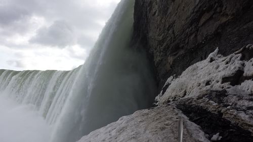 Low angle view of waterfall against sky