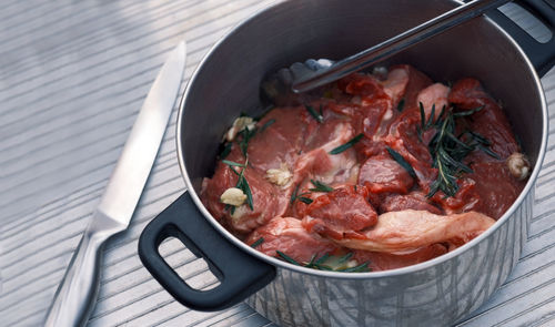 Fresh meat with ingredients for cooking on dark table