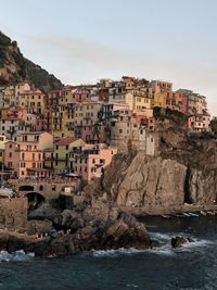 Buildings by sea against sky