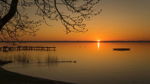 Scenic view of lake against orange sky