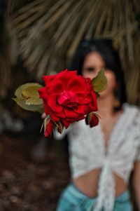 Midsection of woman holding red rose