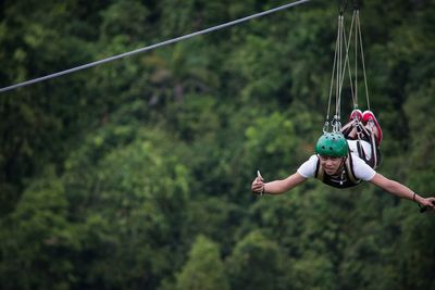 Portrait of man zip lining in forest