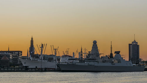 Boats moored at port of hamburg against orange sky