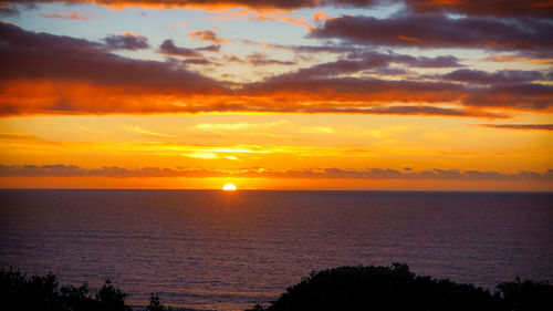 Scenic view of sea against romantic sky at sunset