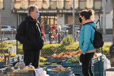 Full length of friends at market stall in city